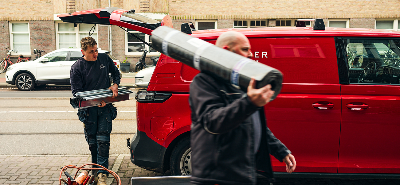 Team van F.P. De Boer laadt materiaal in bij de rode bus