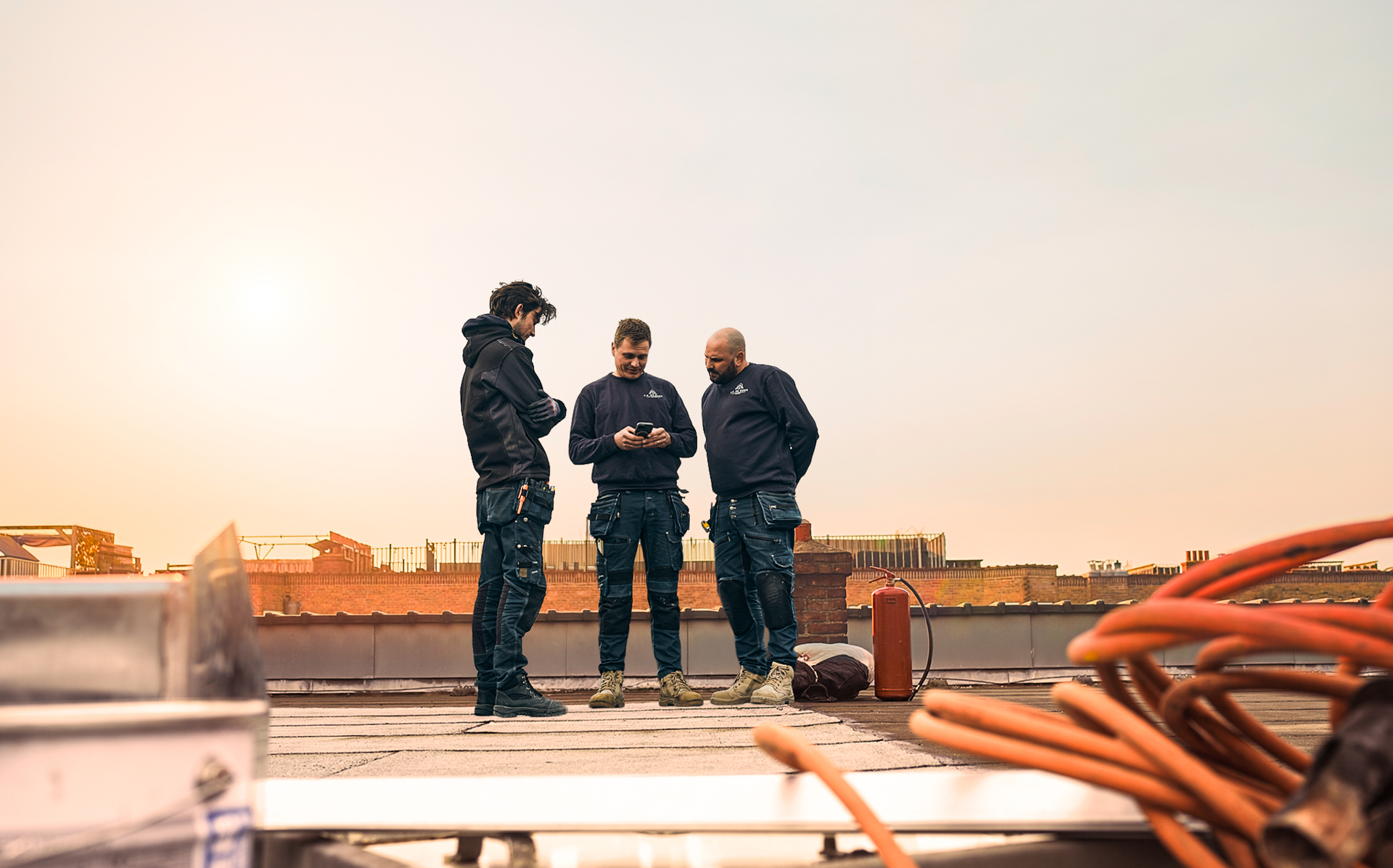 Team van F.P. De Boer Loodgieters op een Amsterdams dak